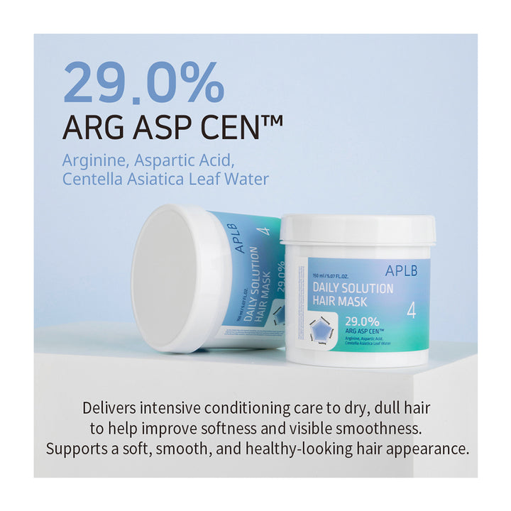 Two white plastic jars of APLB Daily Solution Hair Mask are displayed on a light gray surface against a soft blue background. One jar is lying on its side showing the blue label, and the other is standing upright.