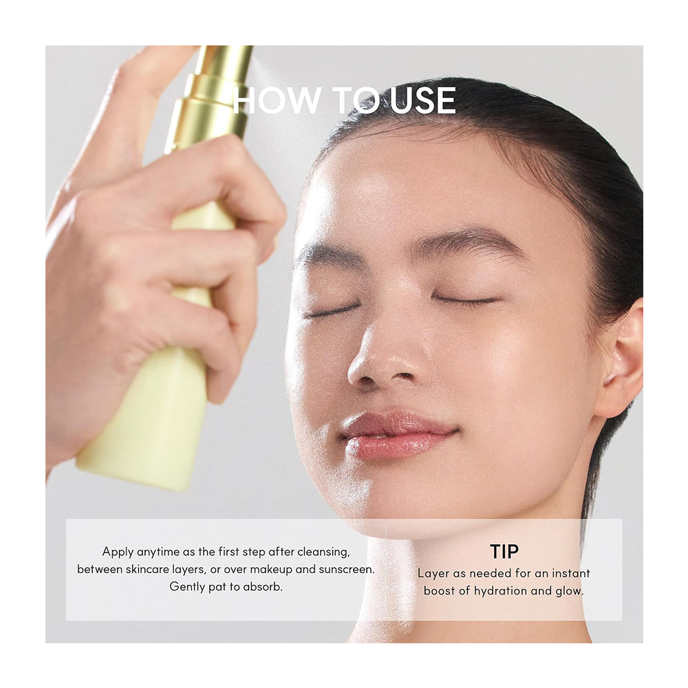 A close-up instructional skincare image showing a woman with closed eyes while a hand sprays a pale yellow cosmetic bottle onto her face. White text at the top reads &
