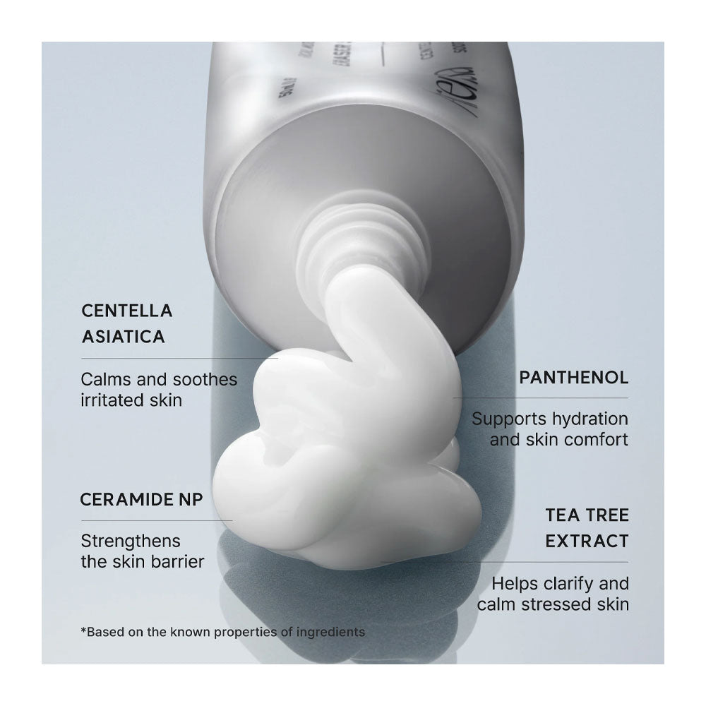A close-up of a white cosmetic tube dispensing thick white cream, with text callouts naming ingredients and benefits including Centella Asiatica, Panthenol, Ceramide NP, Tea Tree Extract, and soothing and hydrating effects.