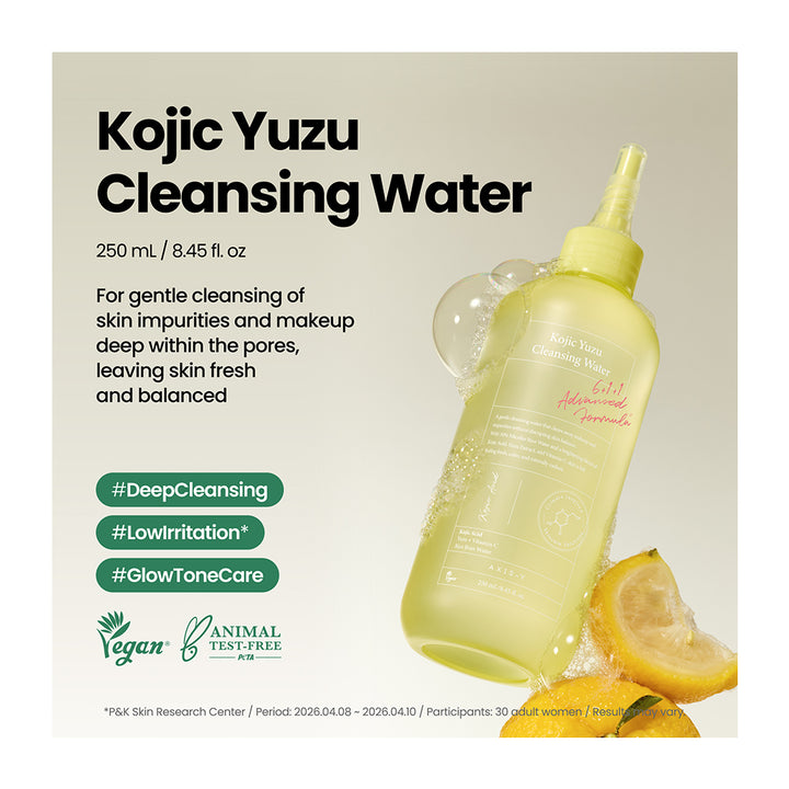 Kojic Yuzu Cleansing Water in a translucent pale yellow bottle with a yellow nozzle, shown on a light beige background with lemon slices, text describing the product, and green certification badges.