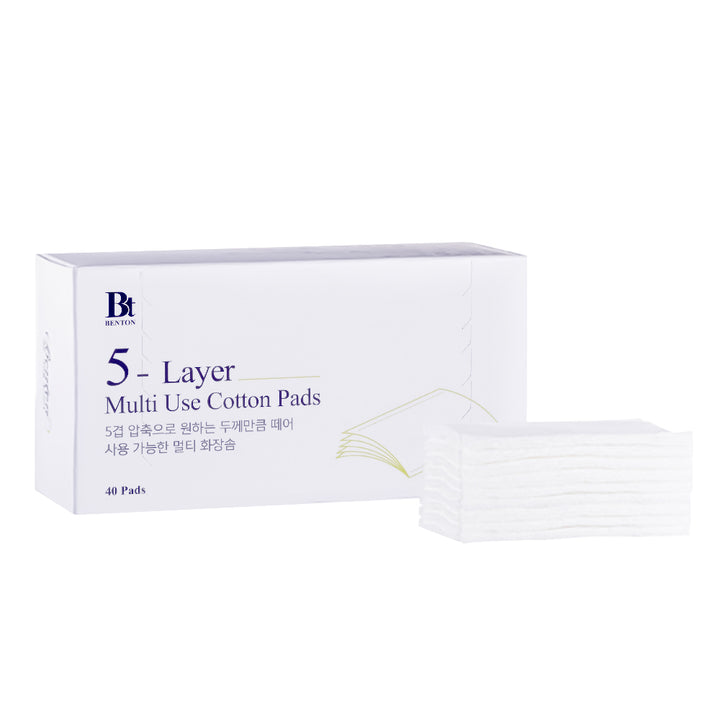 A white box of 5-layer multi-use cotton pads next to a small stack of translucent white pads on a clean white background. The box features a blue &