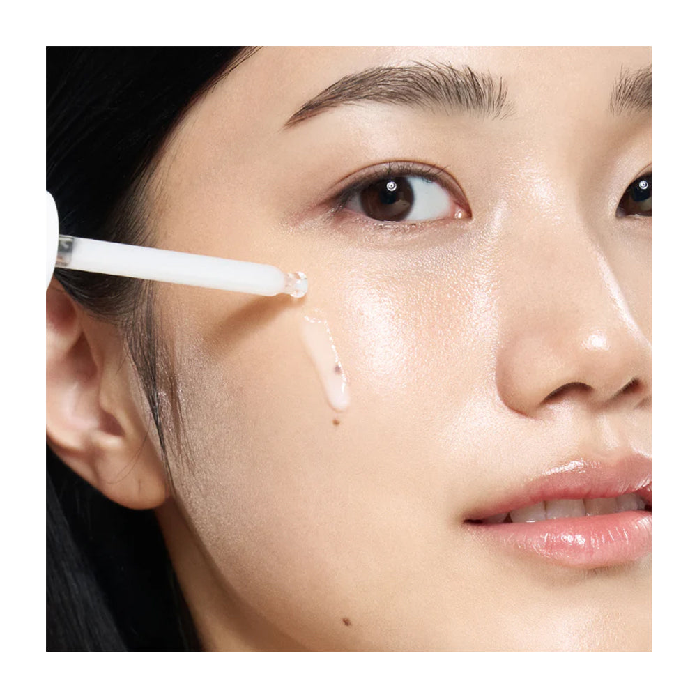 Close-up of a person applying skincare product to their face with a brush.