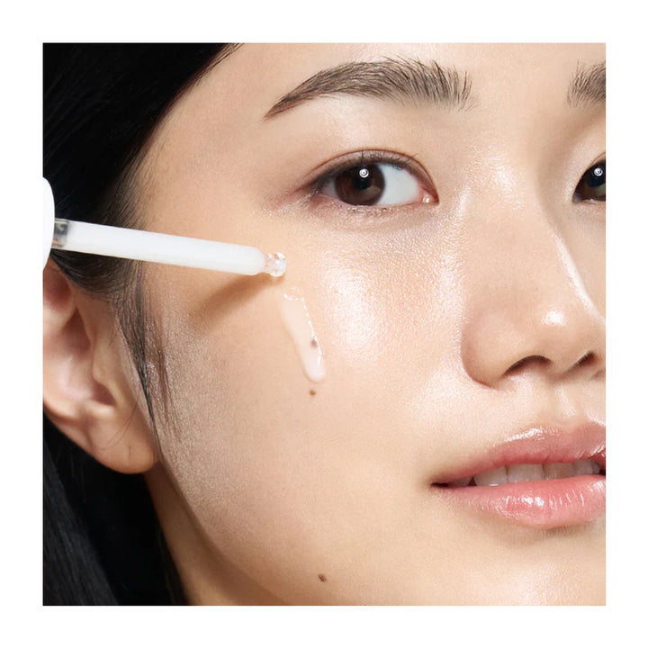 Close-up of a person applying skincare product to their face with a brush.