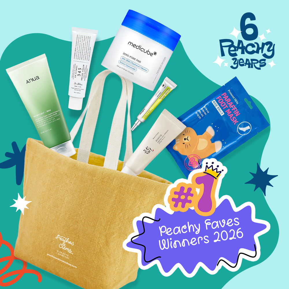 A curated gift set arranged around a tan tote bag on a bright teal graphic background. Visible items include a green gradient skincare tube, a white tube, a white jar labeled medicube, a small yellow-and-white tube, a blue packet of protein powder, and a white tube with a cat illustration.