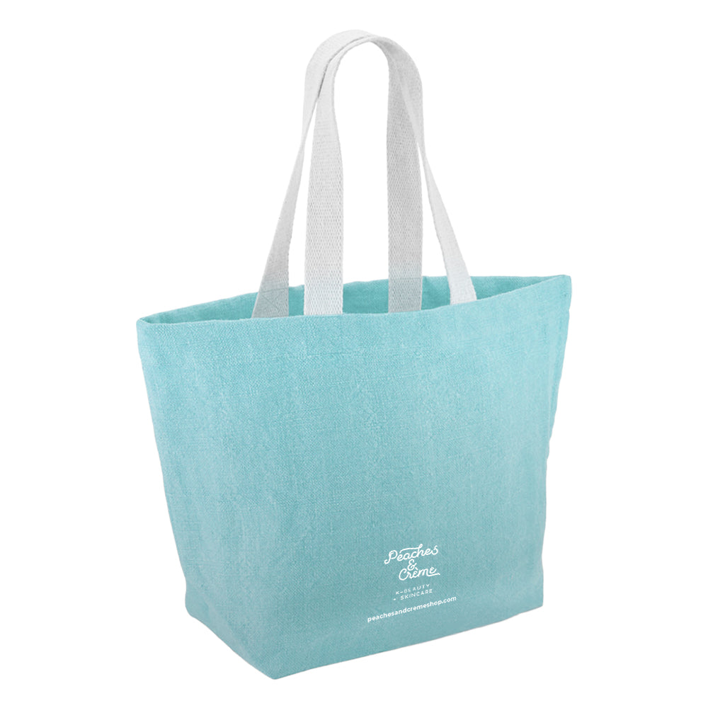 A light blue canvas tote bag with white shoulder straps and white script text on the lower front reading 'Piazza's Coffee'.