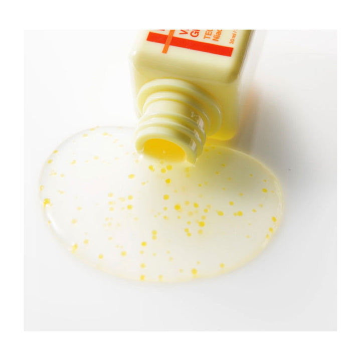 Yellow gel-like substance spilling out of a tube on a white background