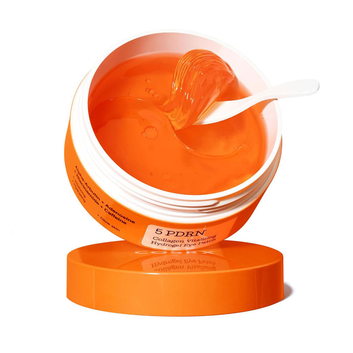 Orange skincare product with a white lid on a white background