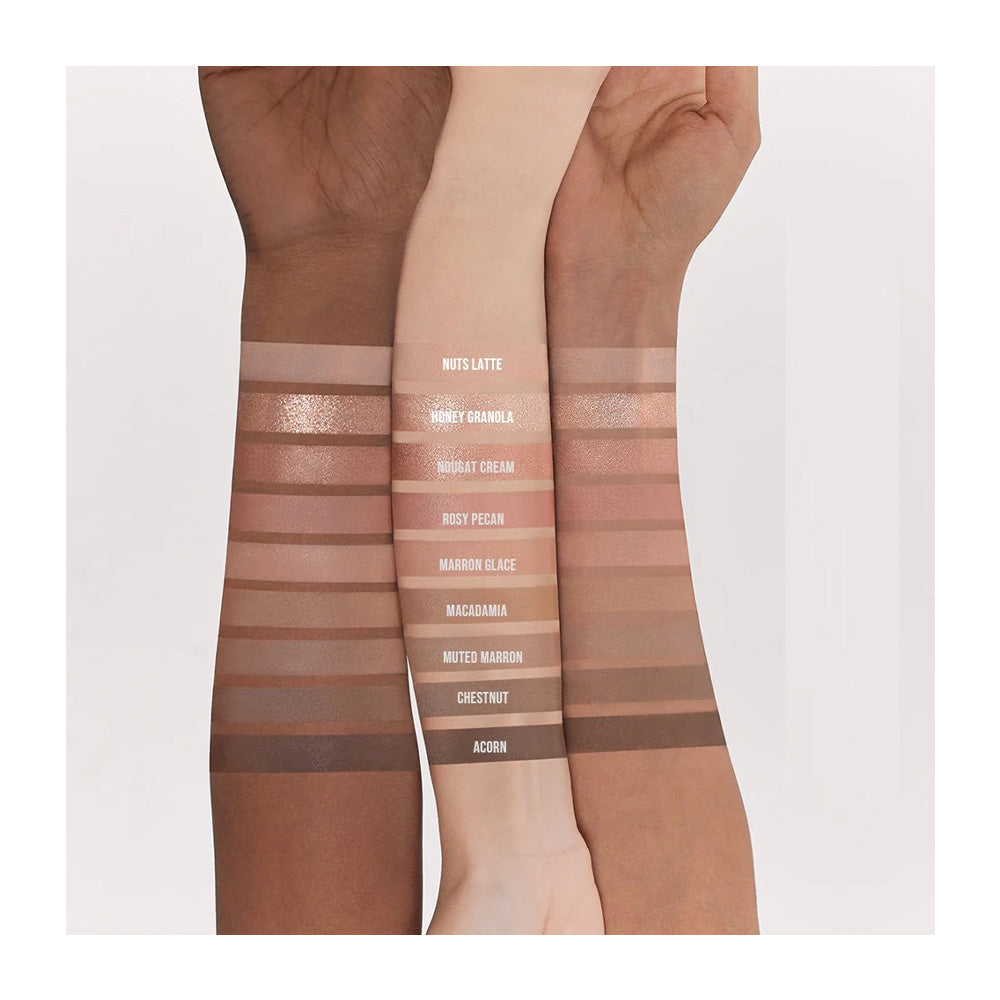Three arms with swatches of different makeup shades on a white background