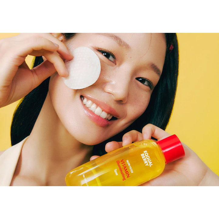 Woman applying a facial patch with a bottle of skincare product against a yellow background