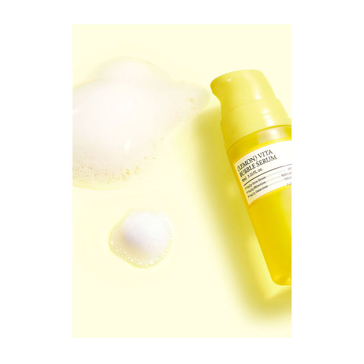 Yellow skincare serum bottle with a droplet on a light yellow background