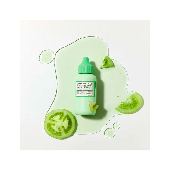 Green tomato peeling serum bottle with slices on a white background