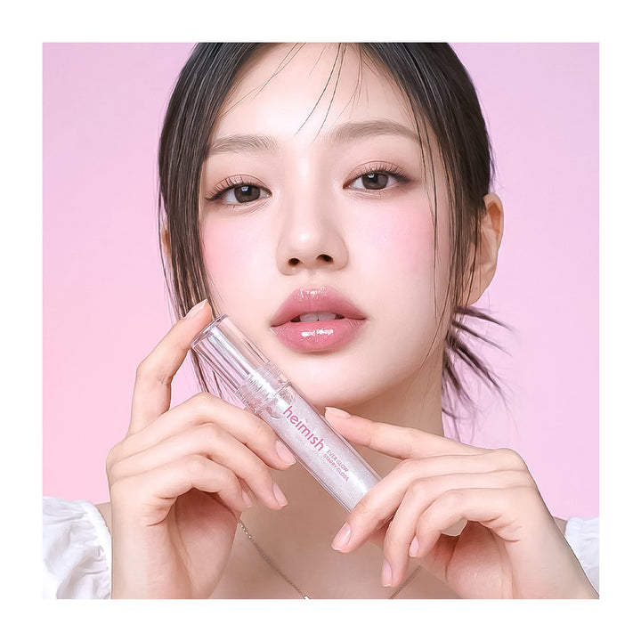 Woman holding a skincare product against a pink background