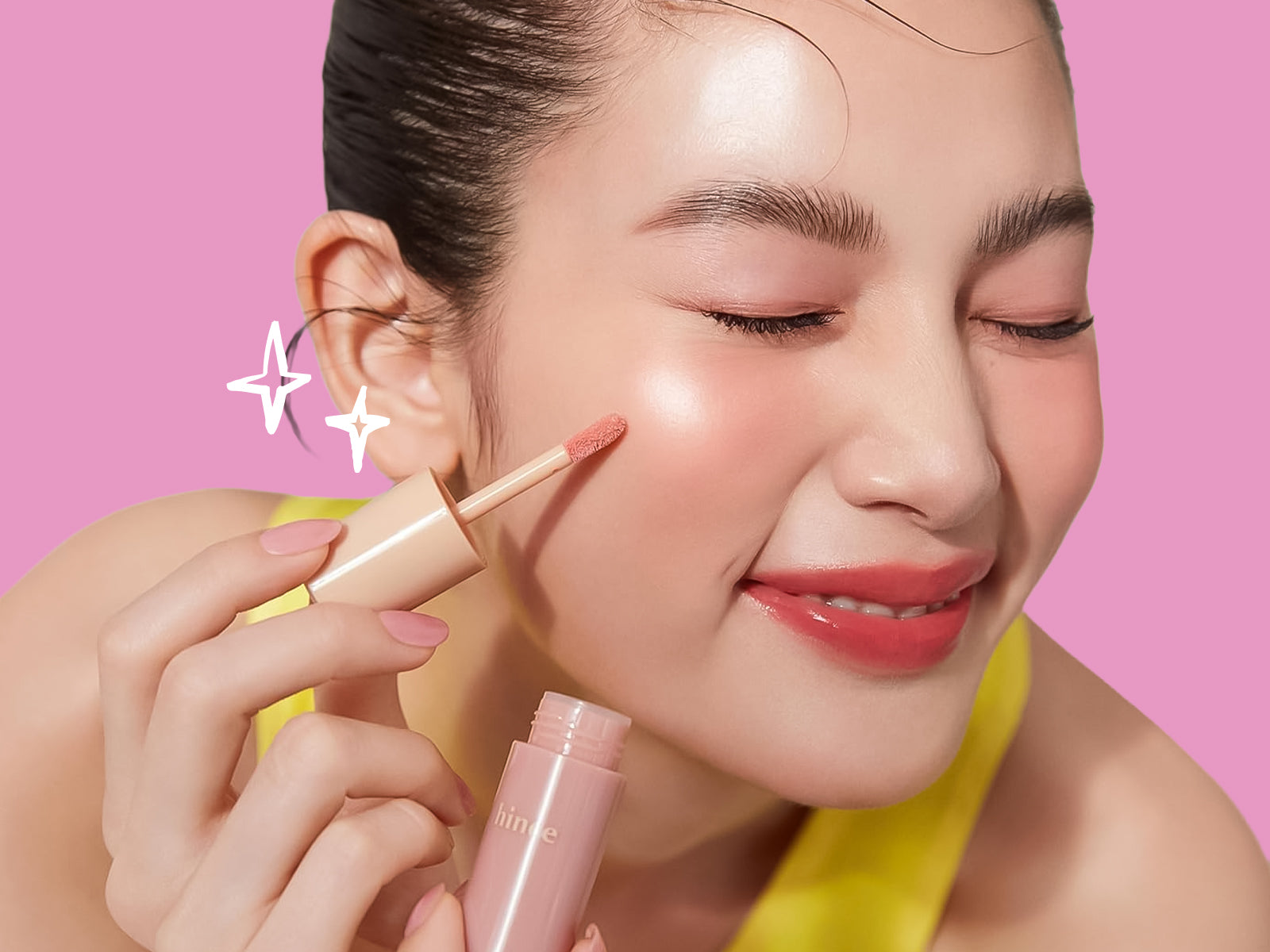 Woman holding a skincare product with a pink background