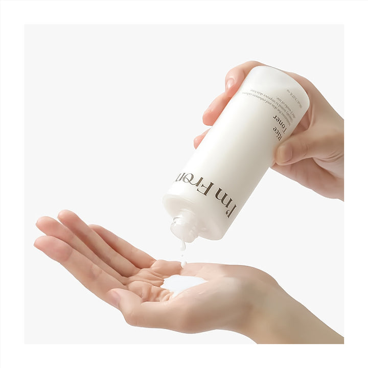 Hand holding a white bottle labeled &