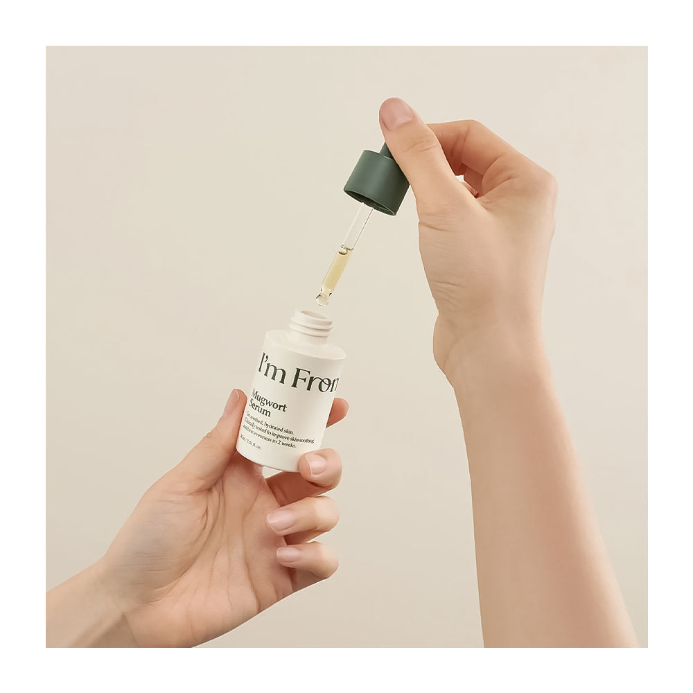 Hand holding a dropper with &