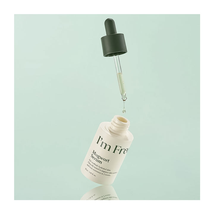 Skincare serum bottle with dropper on a light green background