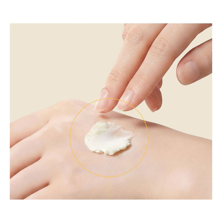 Hand applying cream to another hand with a beige background