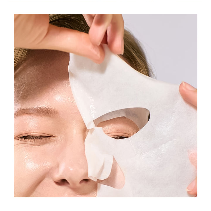 Person applying a white sheet mask to their face