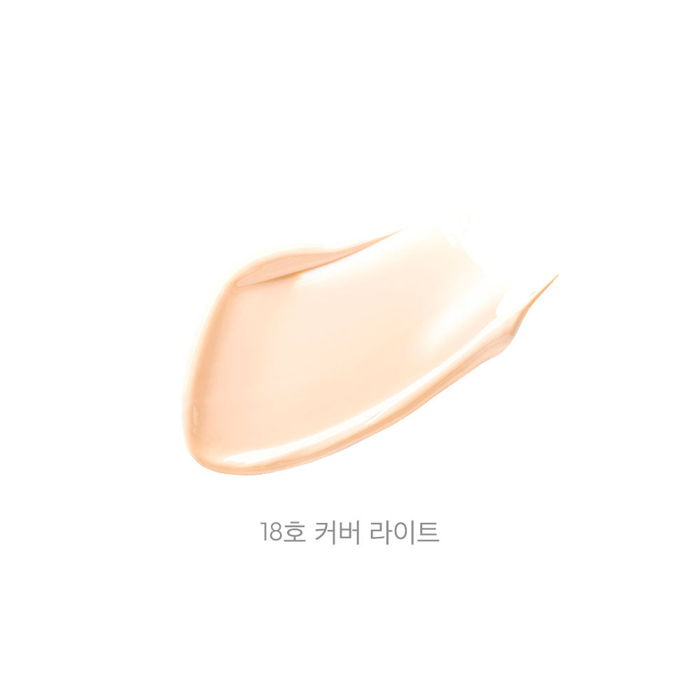 A swatch of light beige liquid foundation or cream makeup on a plain white background, with the text &