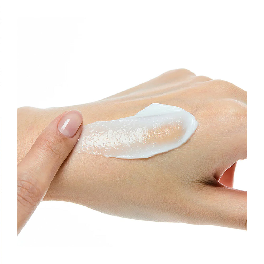 Hand applying a white cream or lotion on a white background