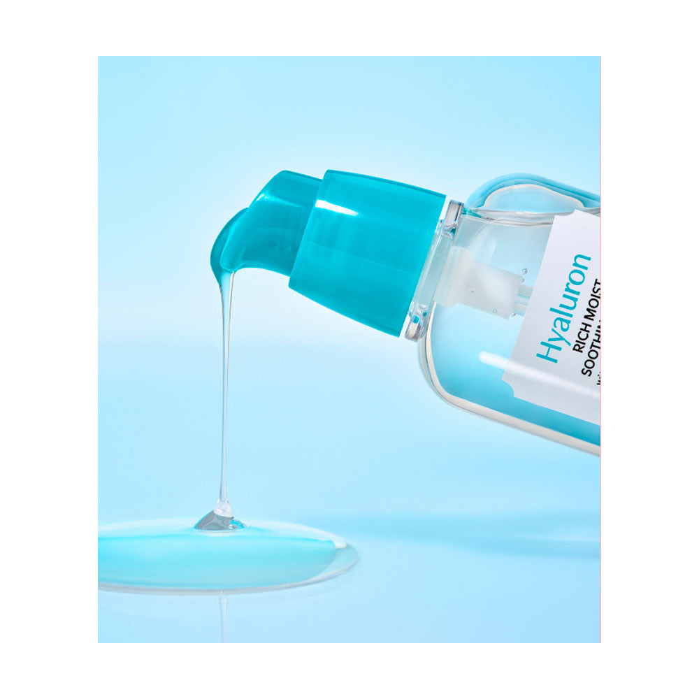 A clear bottle with a bright teal pump dispensing a glossy translucent blue gel onto a light blue surface. The bottle label reads Hyaluron.