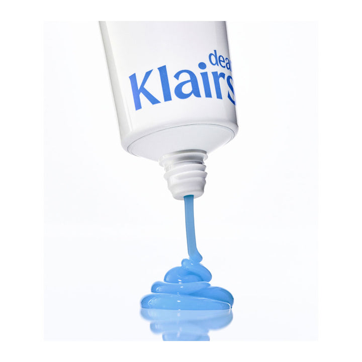 A white squeeze tube of Clairs dental gel, shown tilted with light blue gel being squeezed out in a small pile below, on a clean white background.