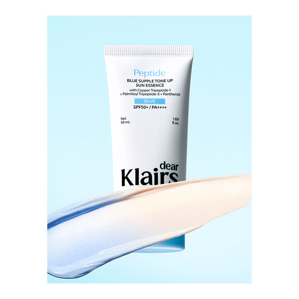 A tube of Klairs Peptide Blue Gummy Tone Up Sun Essence SPF50+ / PA++++ sunscreen cream, shown with a glossy smear of the pale blue product in the foreground against a light blue background.