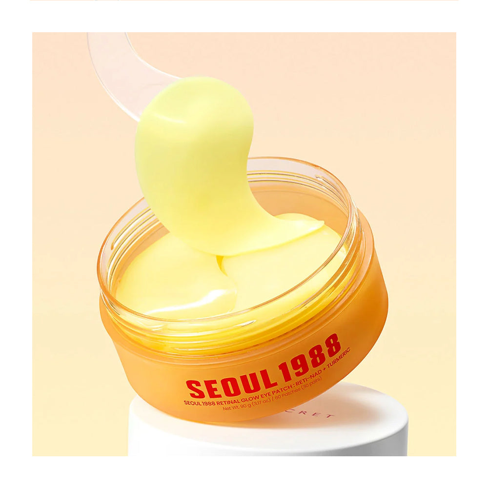 A jar of Seoul 1988 glow patch mask with a translucent scoop lifting a pale yellow patch, set against a soft peach background.