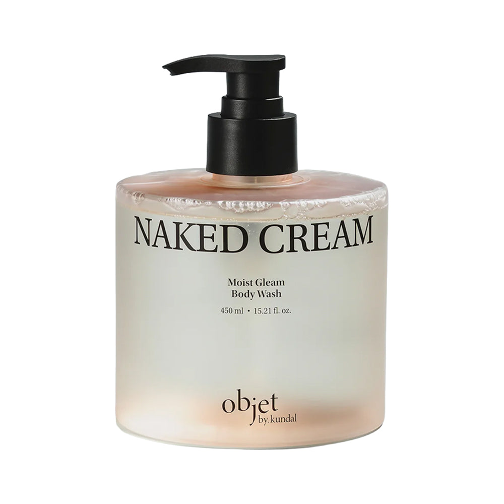 A bottle of objet by kindal Naked Cream Moist Glisten Body Wash, featuring a frosted glass bottle with a black pump dispenser and a soft peach-colored liquid inside, set against a plain white background.