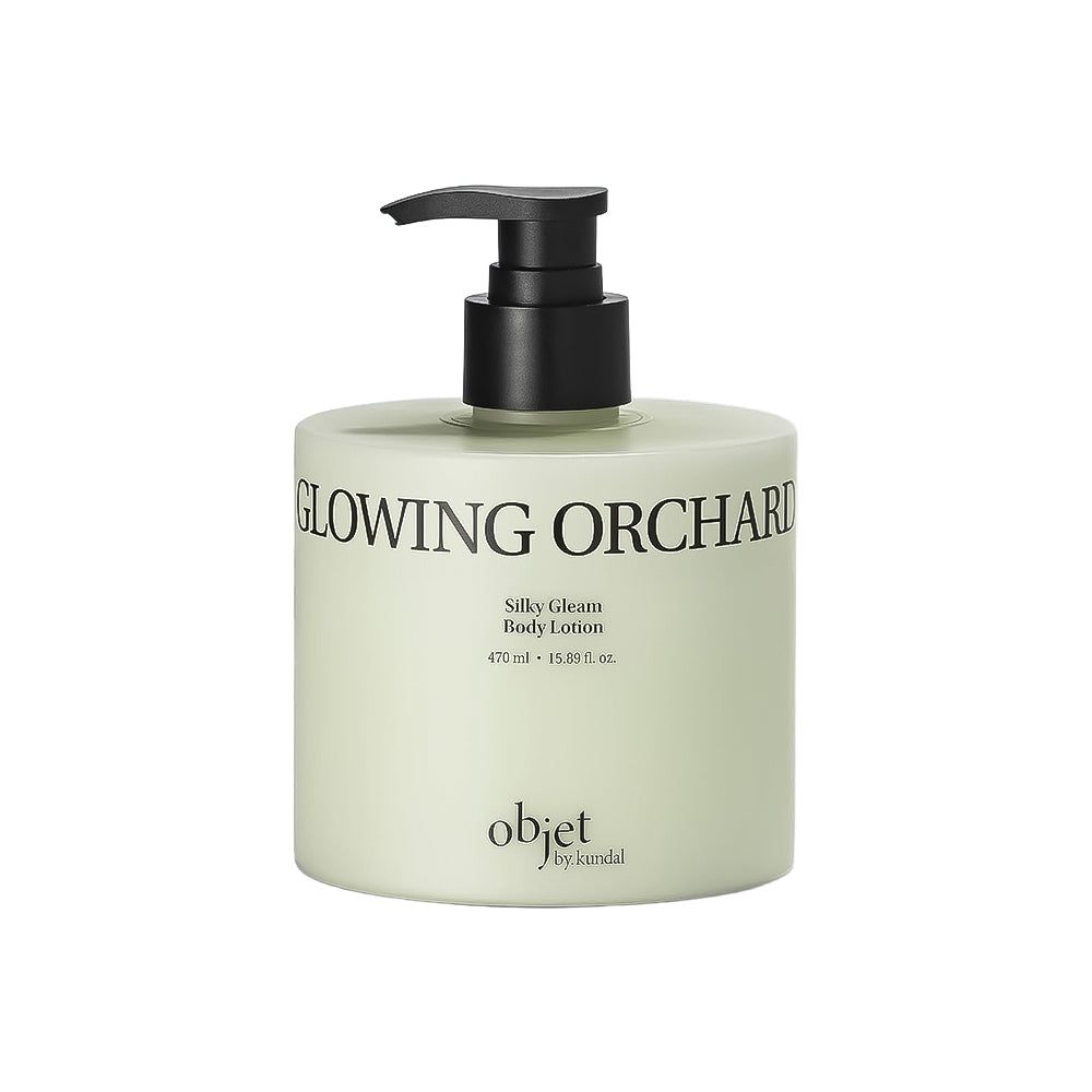 A bottle of objet by scandal Glowing Orchard Silky Cream Body Lotion with a black pump dispenser on a solid white background.