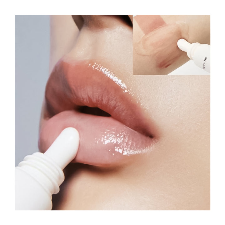 Close-up of glossy nude lips with a white lip product applicator touching the lower lip, plus a small inset showing the product tube tip on skin.