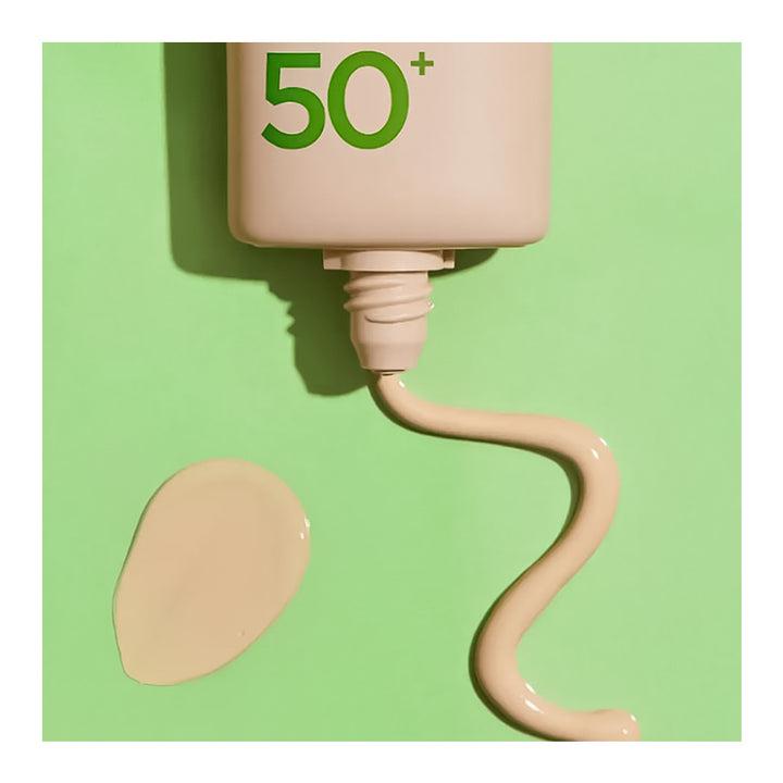 A beige cosmetic tube with green &