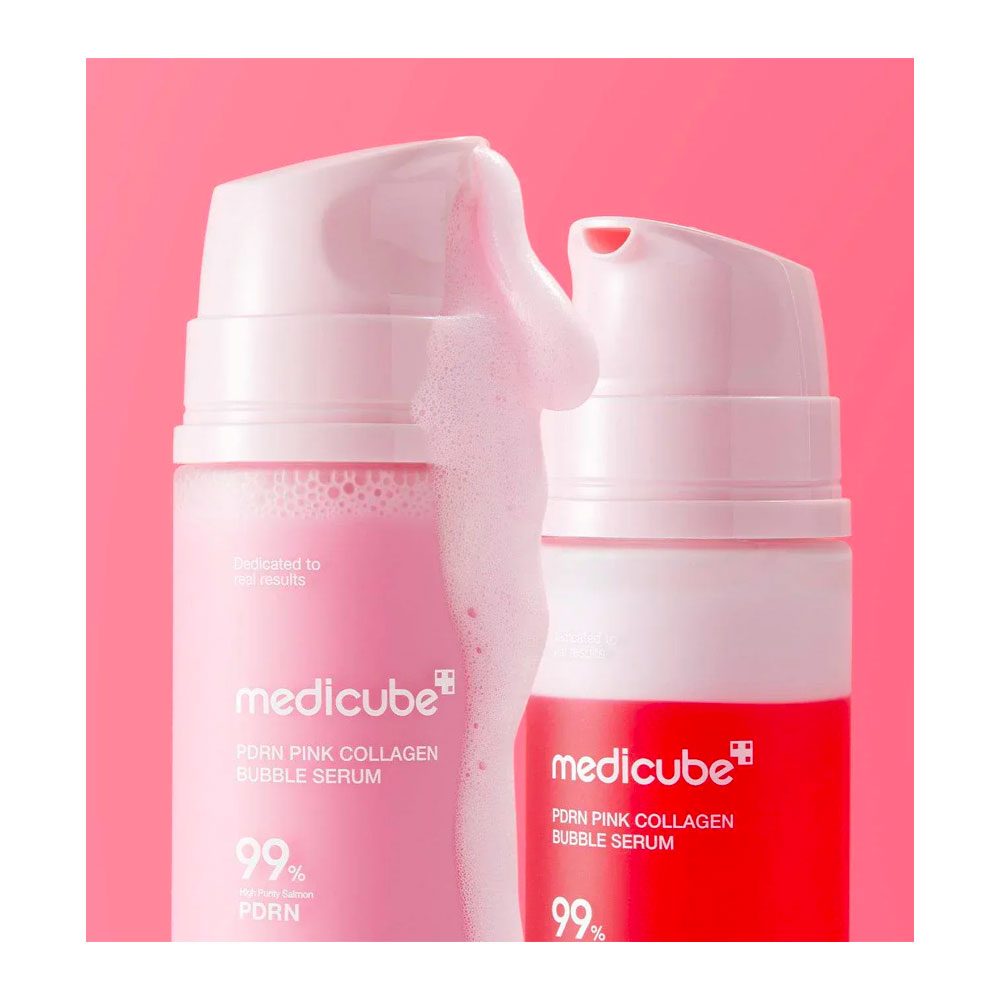 Two Medicube PORN PINK COLLAGEN BUBBLE SERUM pump bottles in pink and red, with one bottle showing a large dollop of pink foam, set against a solid pink background.