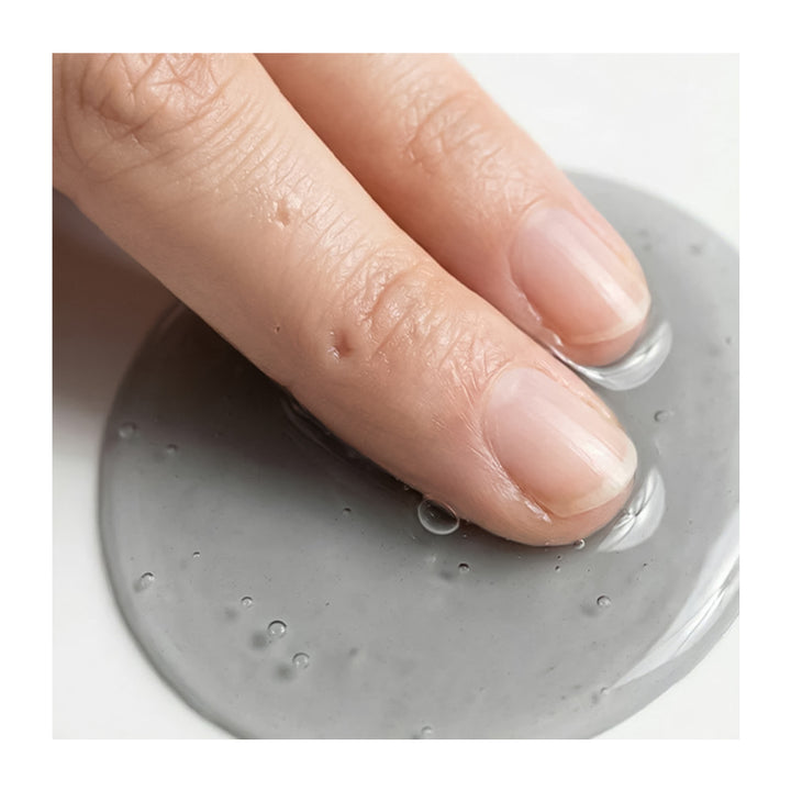 Hand pressing down on a gray silicone mat with water droplets.