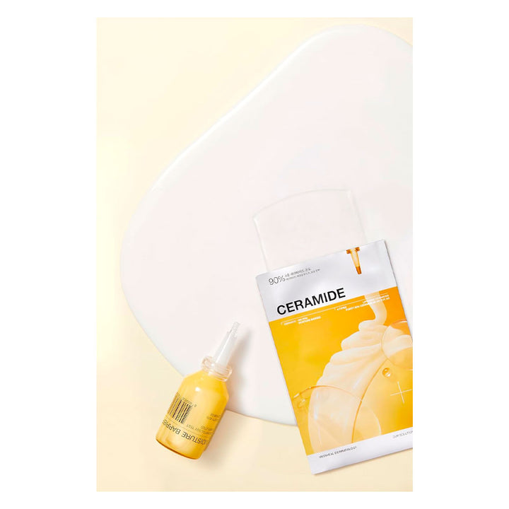 A skincare set featuring a small dropper bottle of yellow serum and a packet of Ceramide moisturizing patches, styled on a light cream background with a white oval prop.
