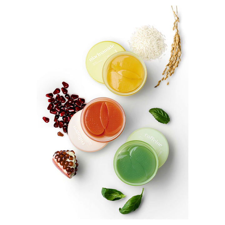 Four small jars with different colored contents on a white background with pomegranate seeds and leaves.
