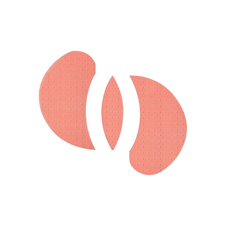 Three peach-colored silicone nipple shields with a textured, dimpled surface, arranged symmetrically on a solid white background.