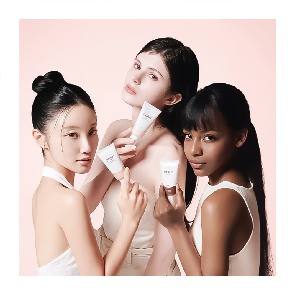Three women holding skincare products against a pink background