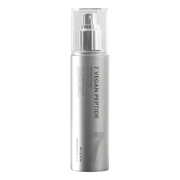 A silver cylindrical cosmetic spray bottle with a clear cap and silver pump, labeled &
