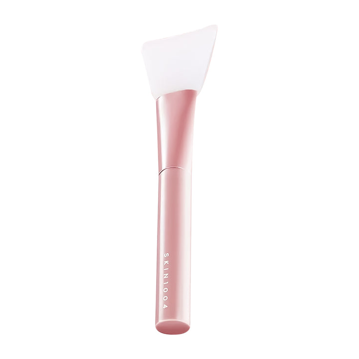 Skincare tool with pink handle and white head on a white background