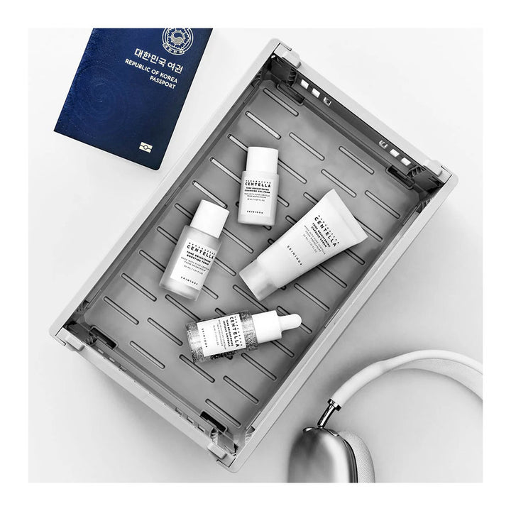 Skincare products on a gray tray with a passport in the background