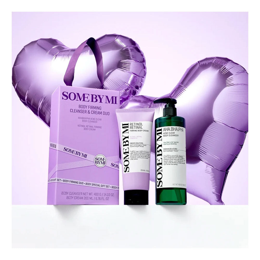 SOME BY MI body firming cleanser and cream duo set, featuring a purple box, a lavender cream tube, and a dark green pump bottle, styled with purple heart-shaped balloons on a light lavender background.