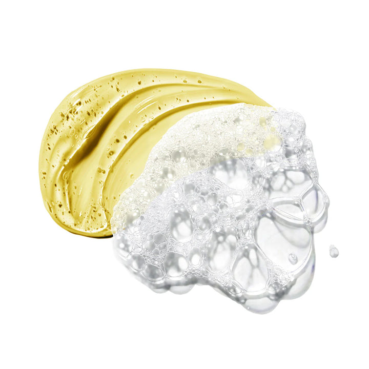 A smear of thick, glossy golden-yellow cosmetic cream transitioning into clear, bubbly foam on a plain white background.