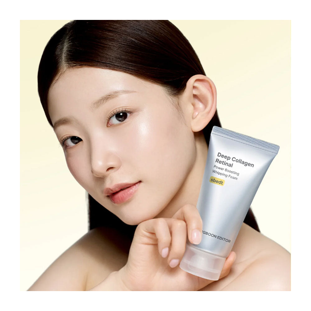 A woman with clear, radiant skin holds a silver tube of Groom Edition Deep Collagen Retinol moisturizing cream against a soft beige background.