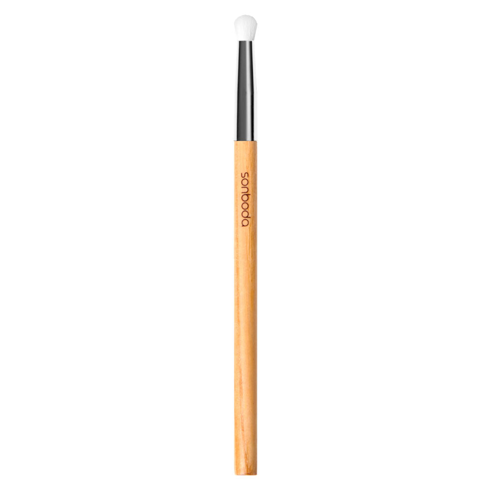A single makeup brush with a light natural wood handle, a black ferrule, and a white bristle tip, shown vertically on a plain white background. The brand name 'soho' is printed on the handle.
