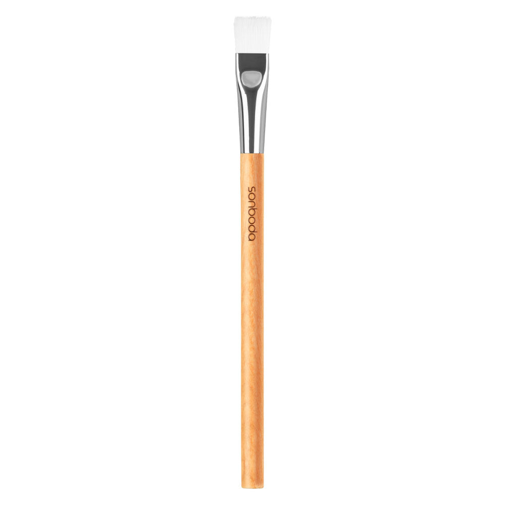 A flat-tip makeup brush with a light natural wood handle, a silver ferrule, and white bristles, shown vertically on a plain white background. The brand name 'softwood' is printed in black on the handle.