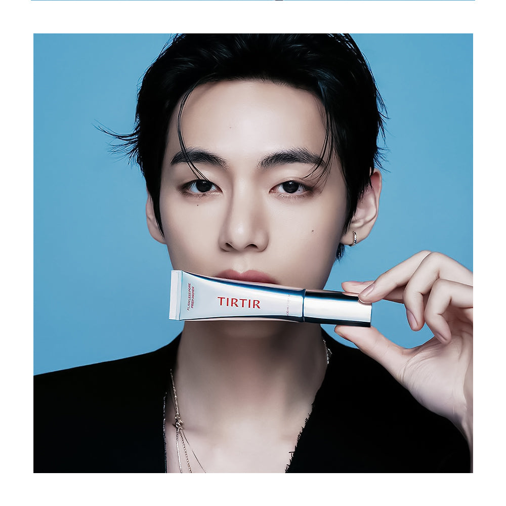 A close-up portrait of a person holding a TIRTIR cosmetic tube against a solid blue background.