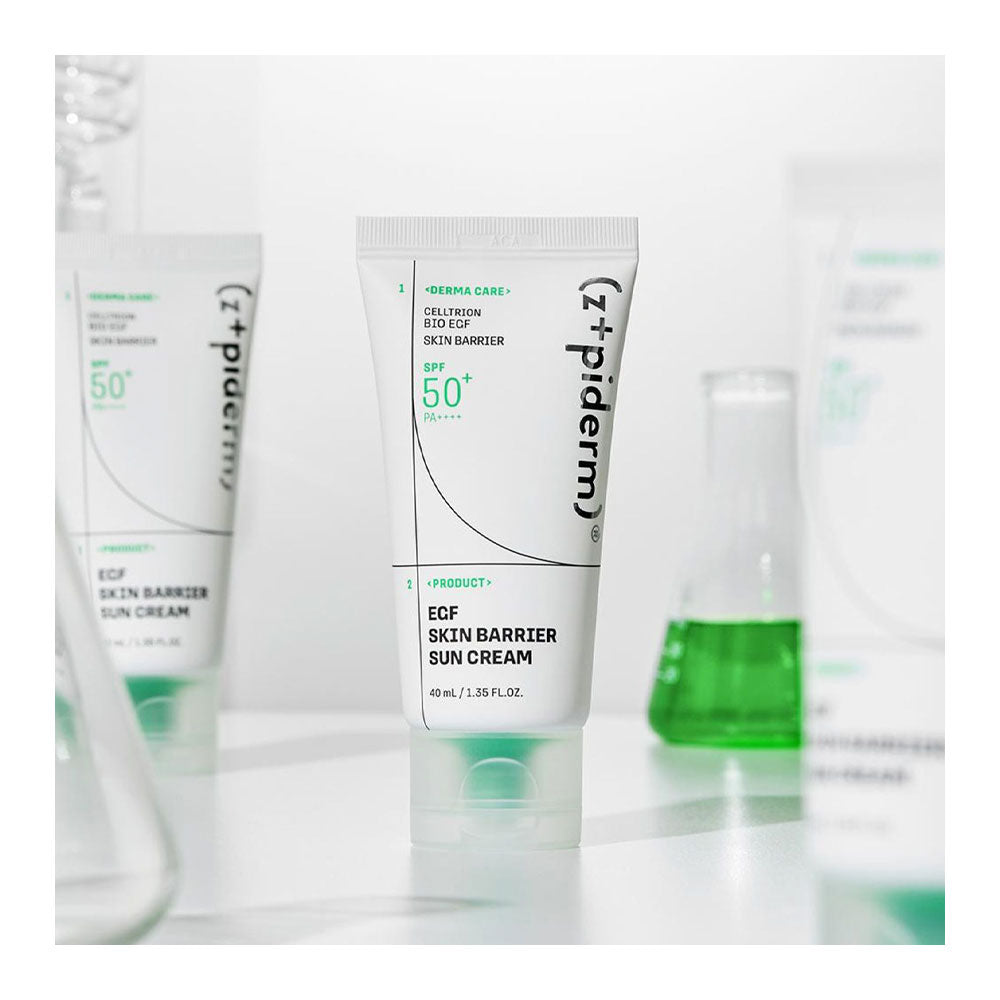 A white tube of Z+piderm ECF Skin Barrier Sun Cream in the shade 50+ is centered in the foreground, with two additional tubes blurred in the background on a clean white surface.